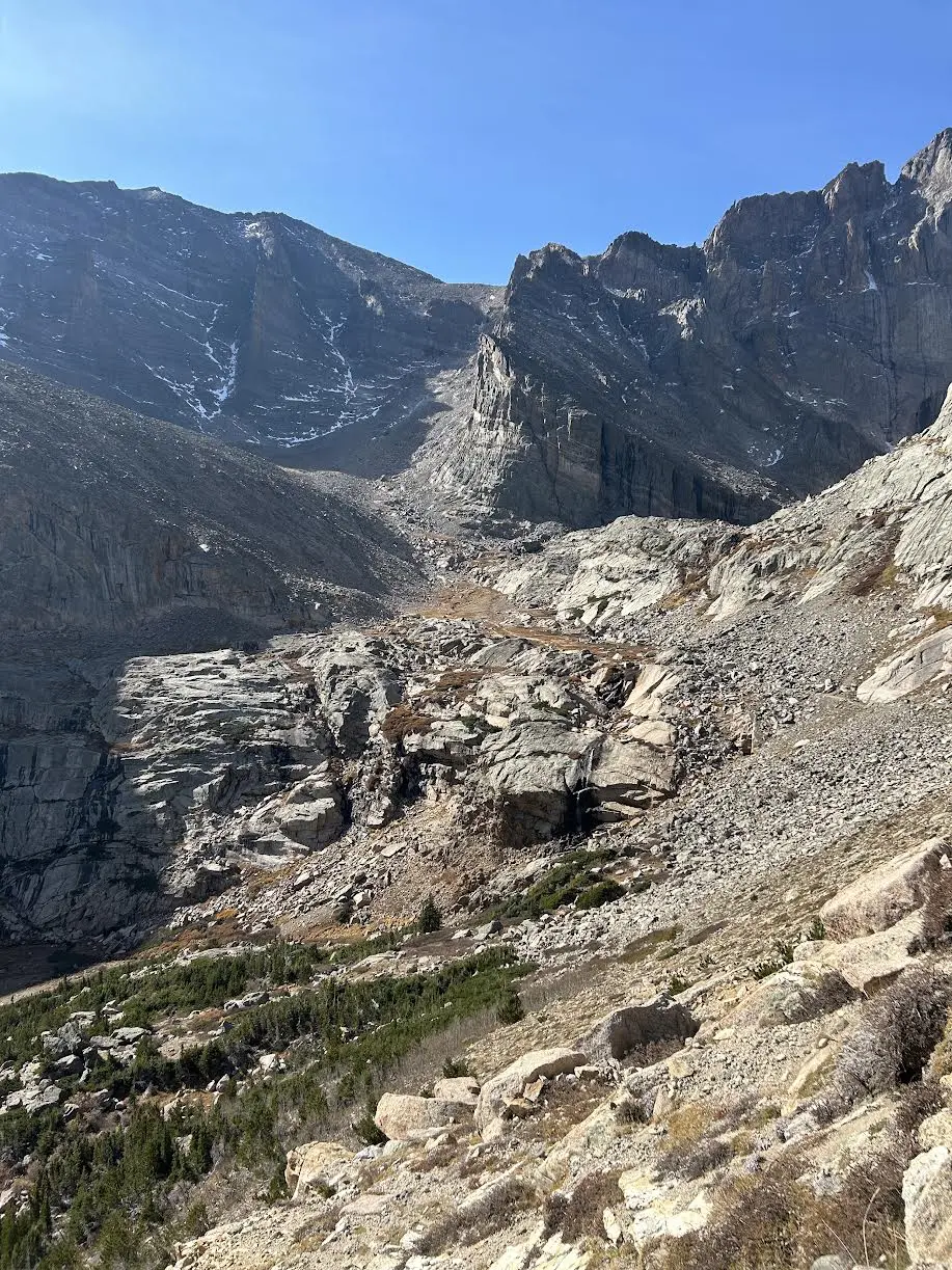 Hikers in the distance with the mountain range looming ahead